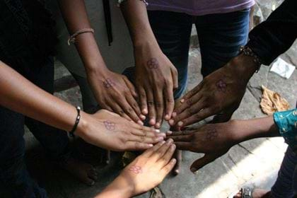 Girls putting hands in together, India