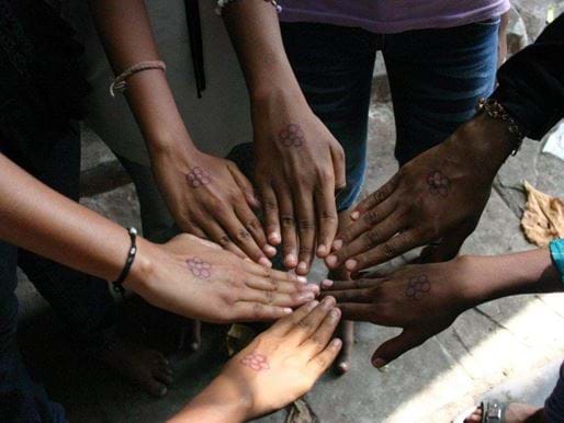 Girls putting hands in together, India