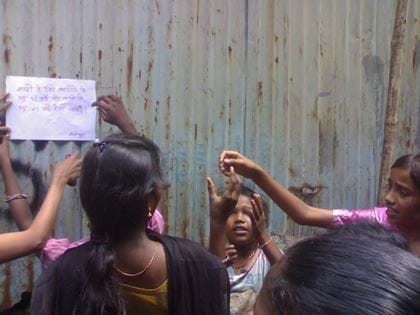 Girls putting up poster, India