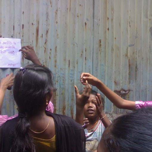 Girls putting up poster, India