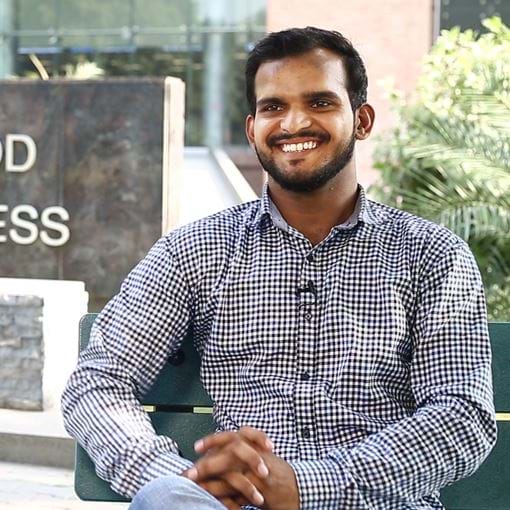 Young man in front of business school, Pakistan